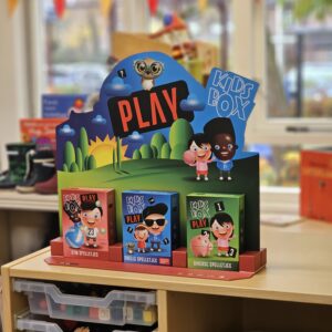 Colorful display of children's toy boxes with cartoon characters on a store shelf in a bright display.