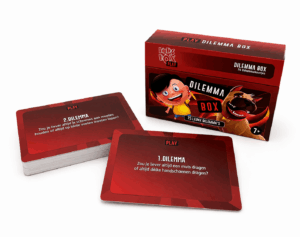 Red Dilemma Box game box with cartoon characters on the cover and two red prompt cards in front on a white surface.
